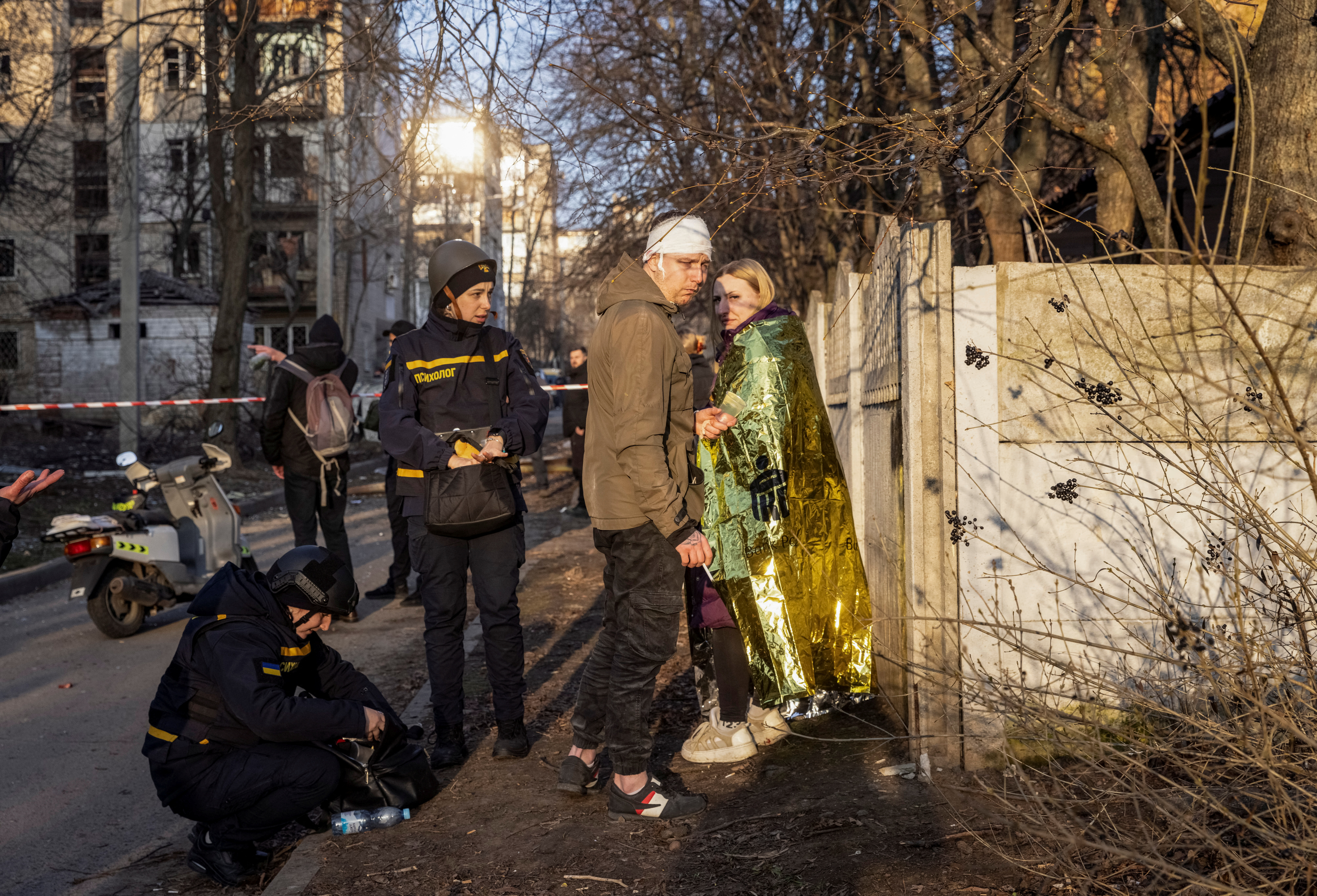 Wounded local residents stand at the site where buildings were damaged by a Russian military strike, amid Russia's attack on Ukraine, in Kharkiv, Ukraine March 27, 2024. REUTERS/Yevhen Titov
