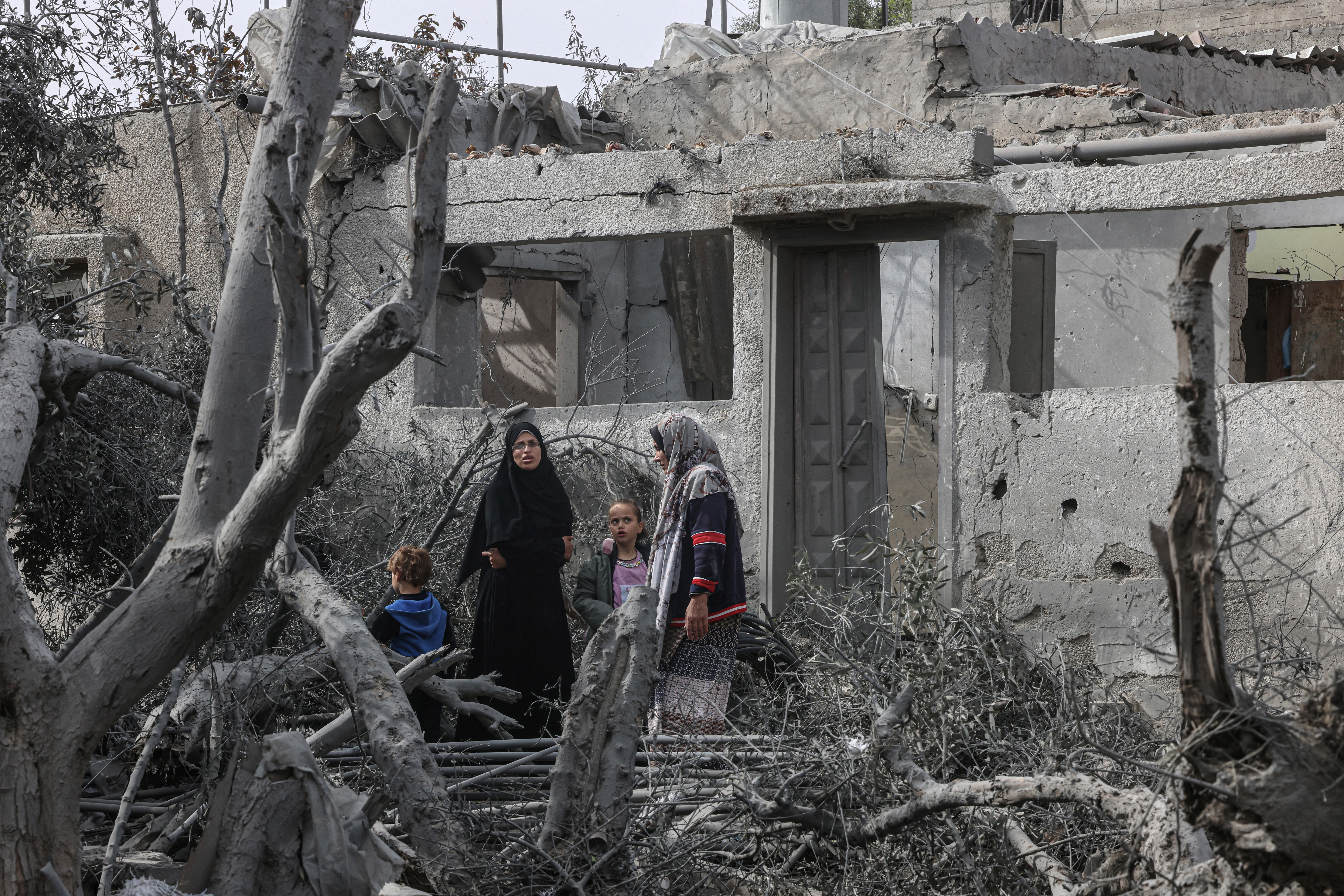 Palestinians inspect the damage to a building after overnight Israeli bombardment in Rafah in the southern Gaza Strip