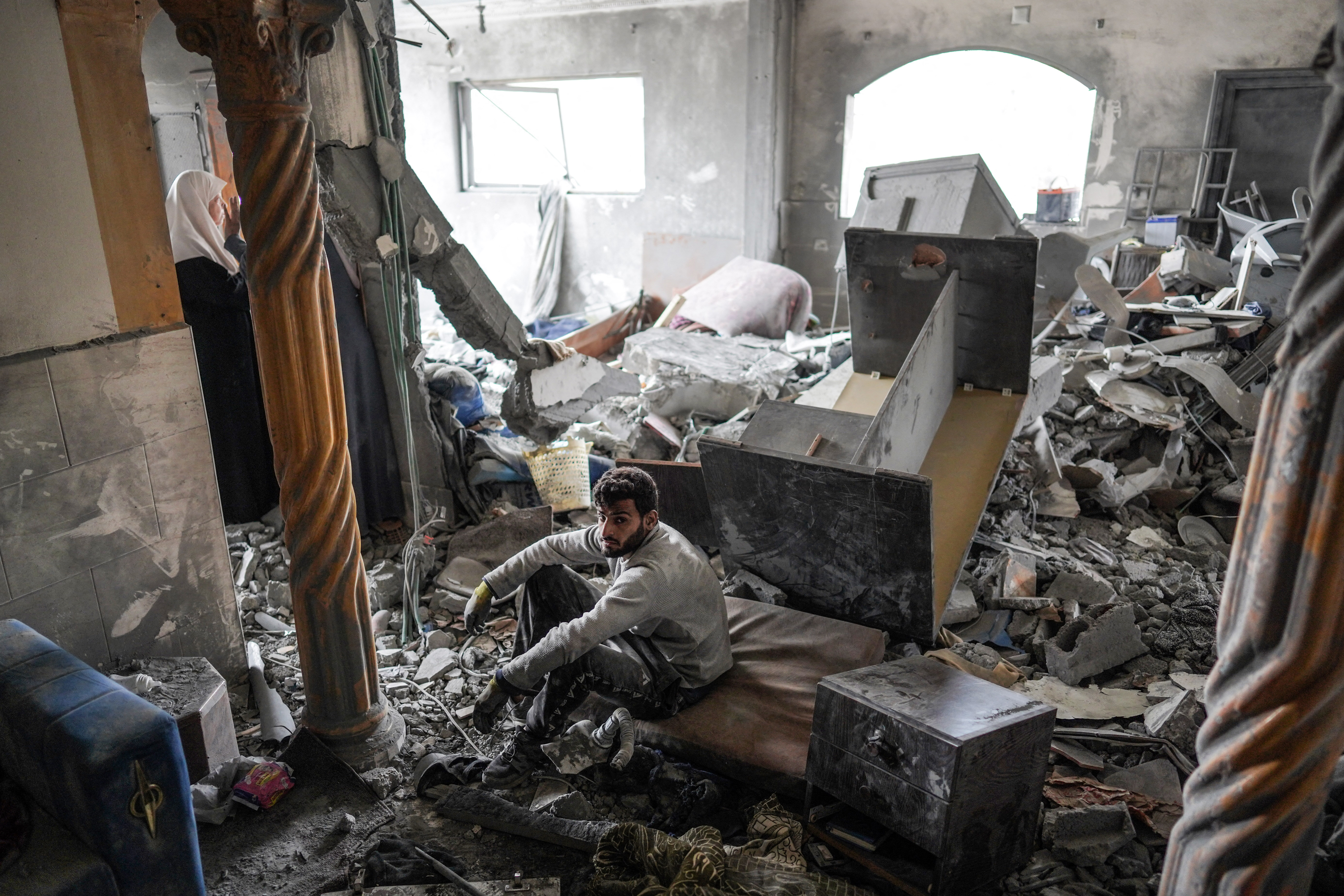 A Palestinian man inspects the rubble in a house, following Israeli bombardment