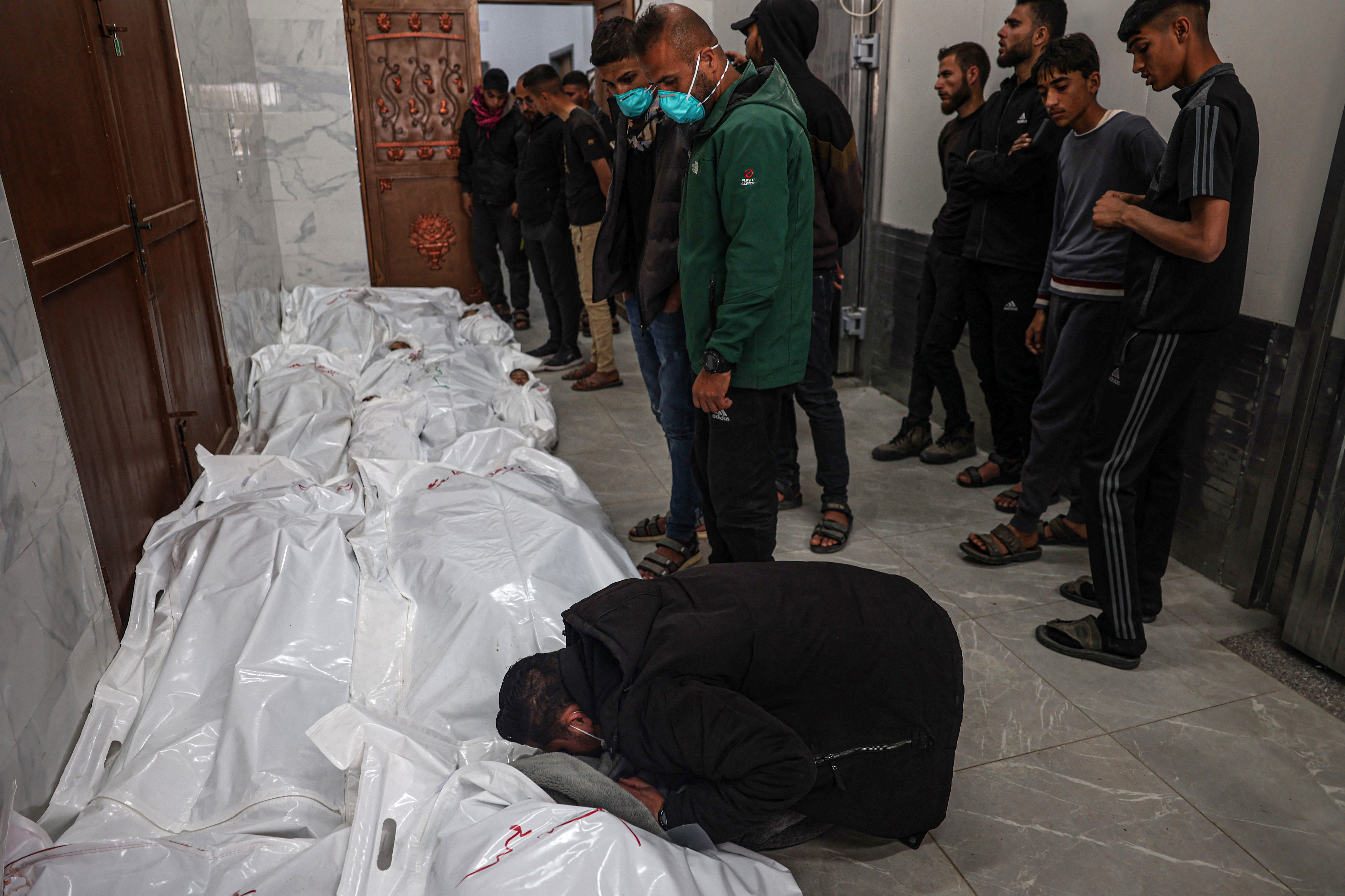 Palestinians mourn over the body of relatives