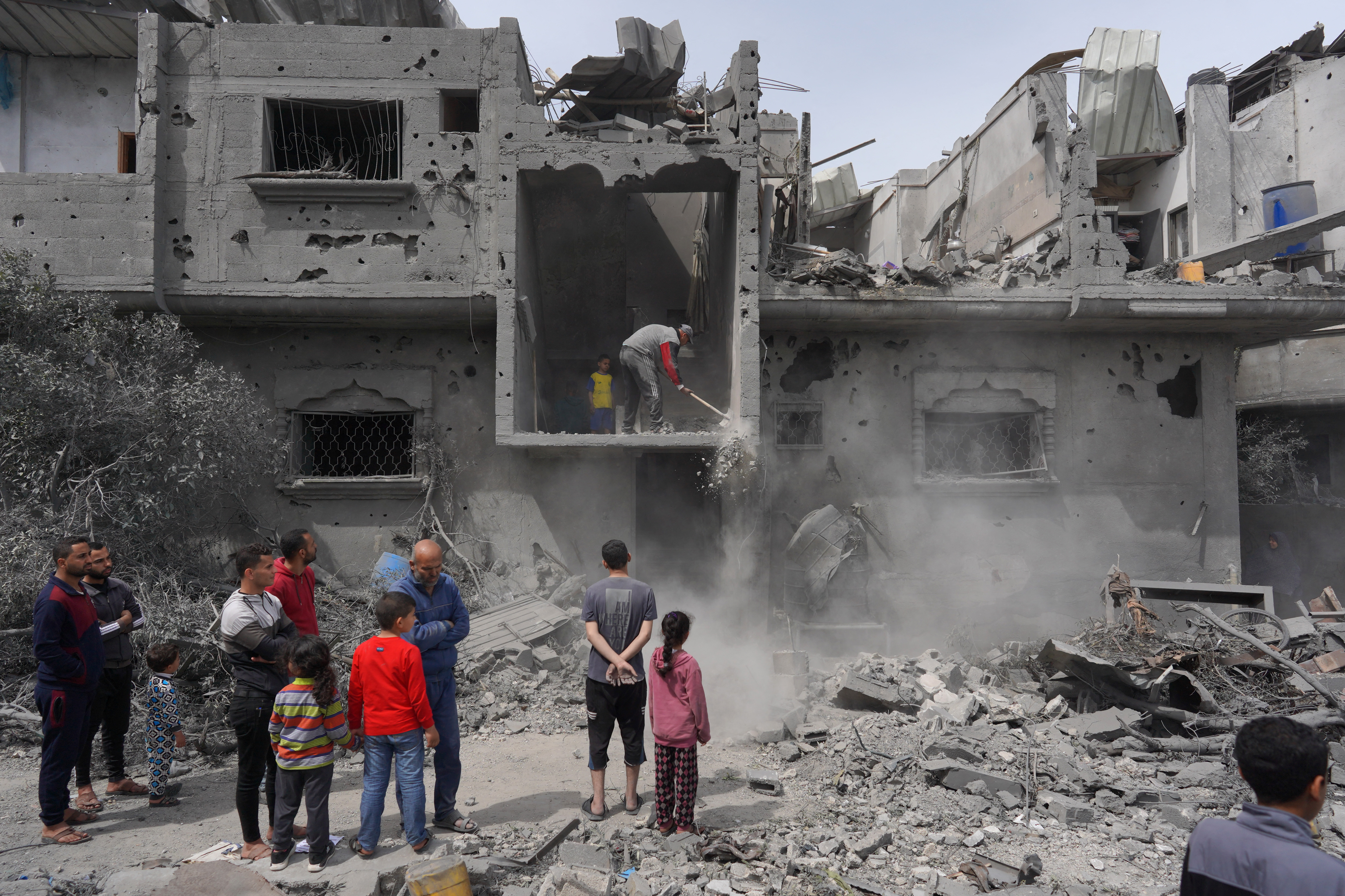 Palestinians clear debris from a building, following Israeli bombardment