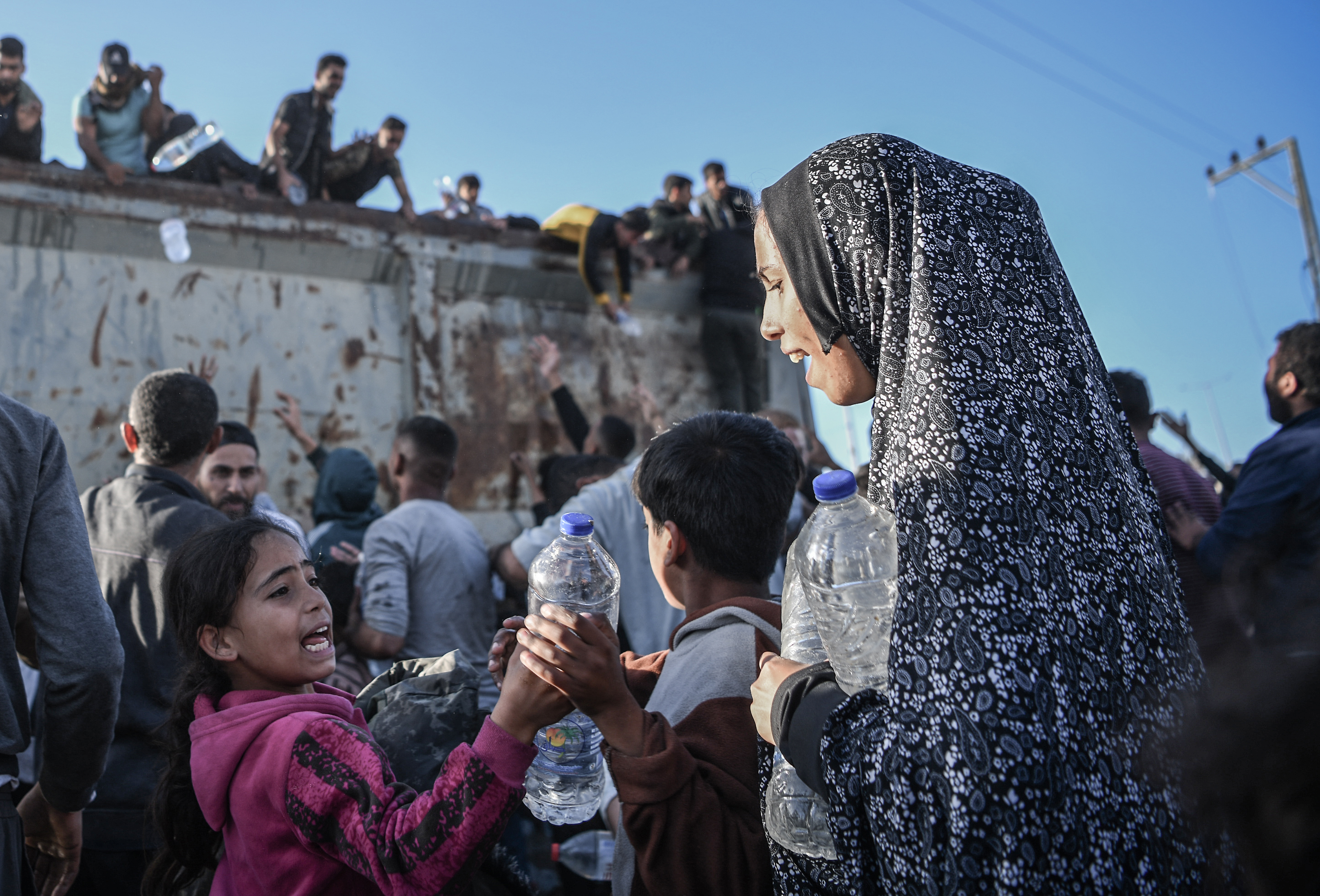 Palestinians flock to the truck carrying drinkable water as they face the threat of hunger and thirst in Rafah, Gaza on December 11