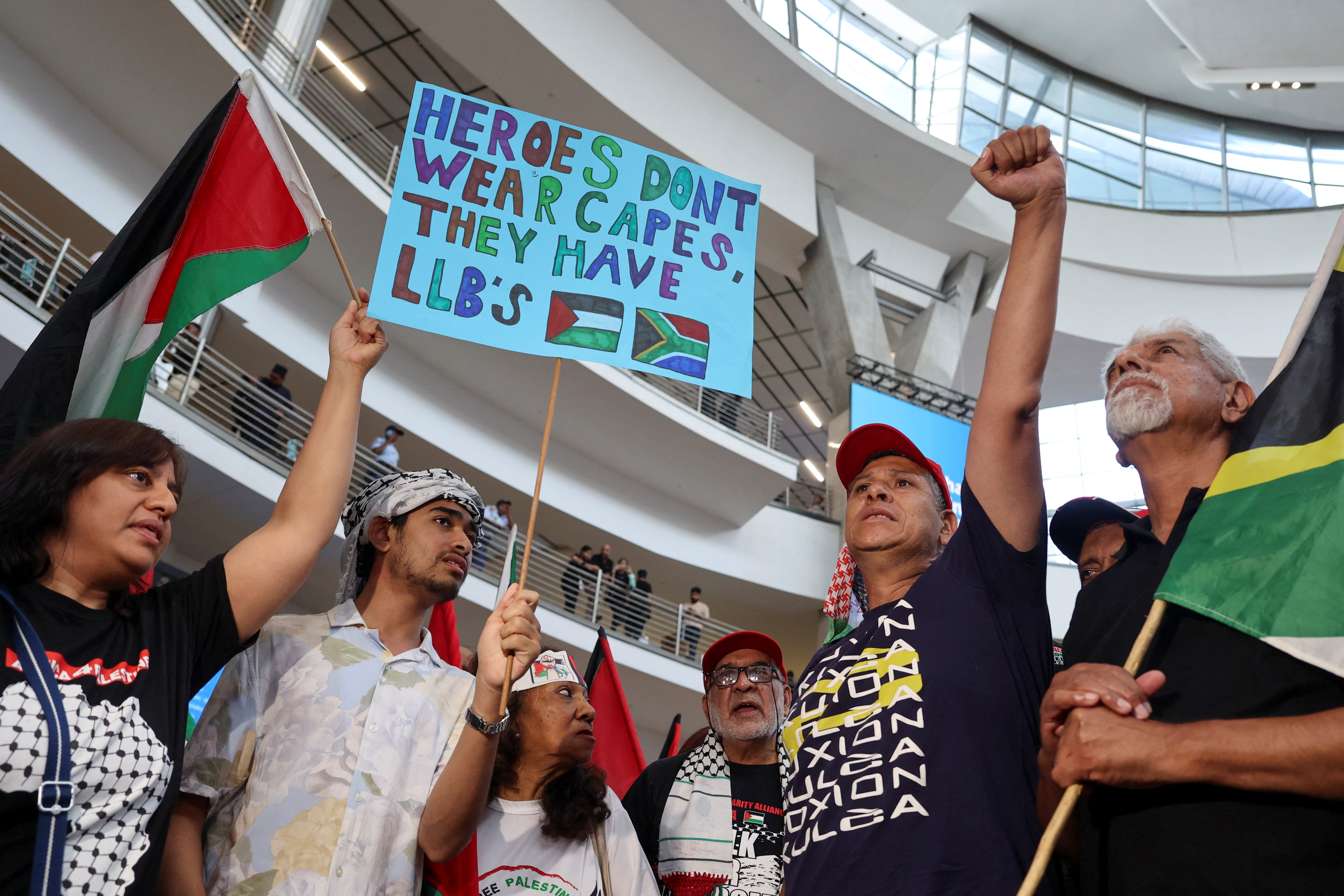 People gather as they wait for the arrival of the legal team representing South Africa's case against Israel at the Court of Justice at Johannesburg international airport, South Africa on January 14, 2024
