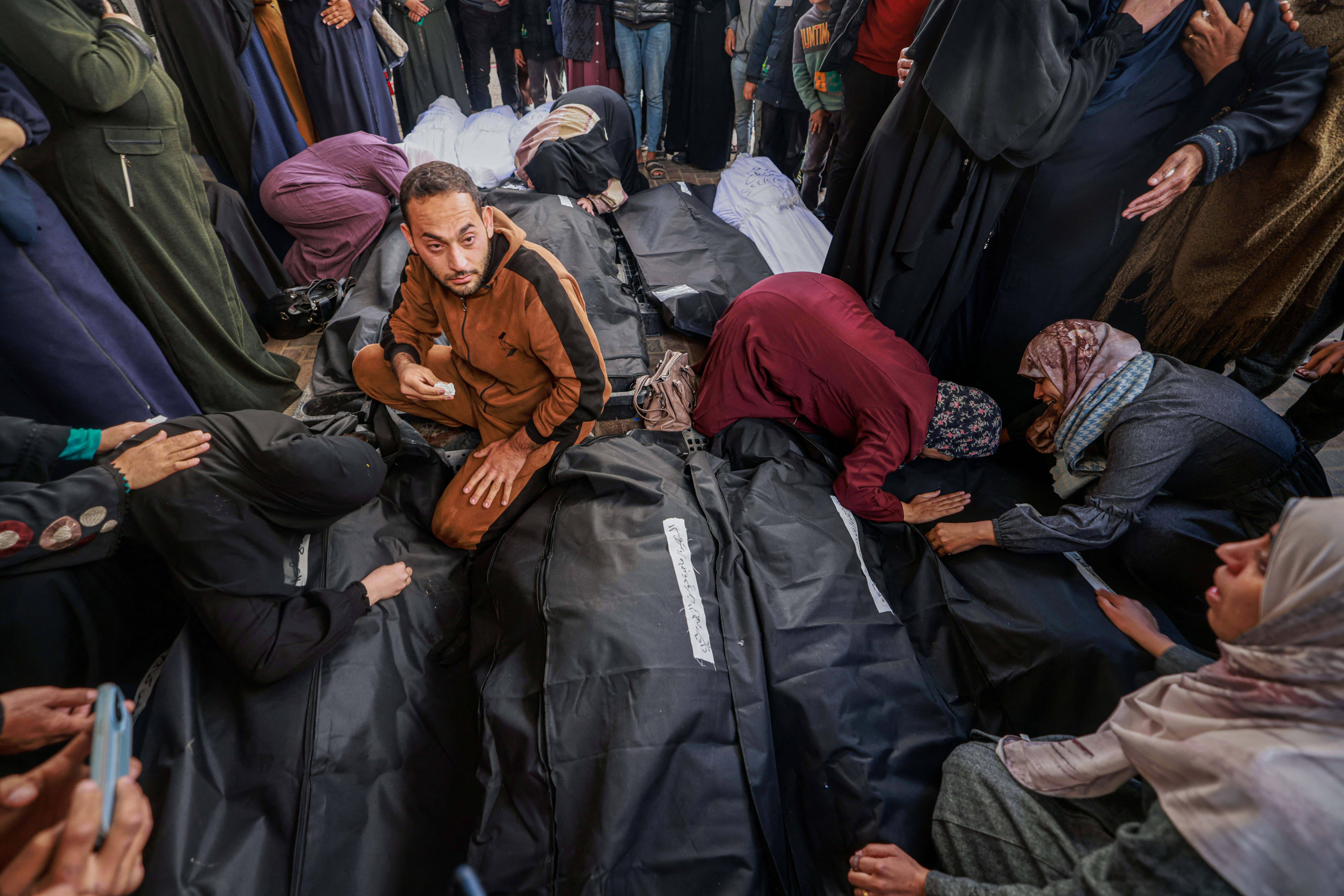 Palestinians mourn by the bodies of relatives who were killed in overnight Israeli air strikes on the Rafah refugee camp